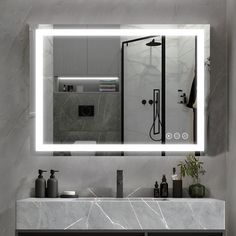 a bathroom with a sink, mirror and lights on the wall above it's counter