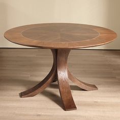 a round wooden table sitting on top of a hard wood floor