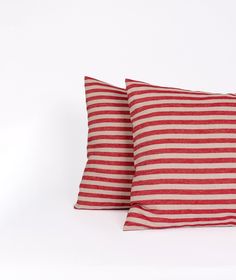 two red and white striped pillows sitting on top of each other