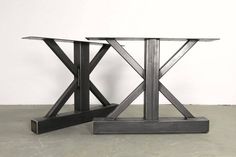 a table that has been made out of metal and is sitting on the floor next to another table