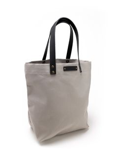 a white bag with black handles and straps on the front, sitting against a white background