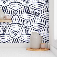 two vases are sitting on a shelf in front of a blue and white wall