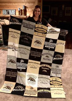 a woman holding up a quilt made from old shirts