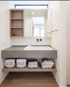 a bathroom with two sinks and baskets on the counter