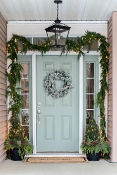 a front door decorated for christmas with wreaths and lights