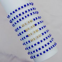 a stack of blue and white bracelets on top of each other with gold beads