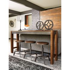 a table with three stools in front of it and a clock on the wall