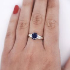 a woman's hand with a diamond and sapphire ring