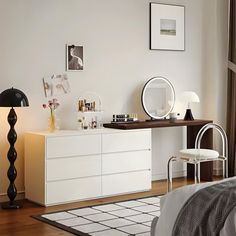 a bedroom with a bed, dresser and mirror on the wall next to a window