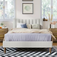 a bedroom with a bed, dressers and pictures hanging on the wall above it