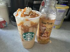 there is a drink with whipped cream and caramel on it next to a bottle