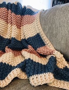 a crocheted blanket sitting on top of a couch