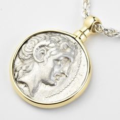 This silver coin was minted in Thrace, Greece between 306 and 281 BCE The face of the coin features a Diademed head of the deified Alexander the Great, and the rear features Athena, seated, holding a winged Nike The coin frame was handmade, in house, in 14k yellow gold, with a swivel bail A certificate of authenticity accompanies your purchase Goldmakers Jewelry Mission Statement Goldmakers Jewelry creates and curates a comprehensive selection of artfully designed hand-crafted jewelry out of our Mythological Silver Jewelry With Coin Pendant, Silver Mythological Jewelry With Coin Pendant, Luxury Engraved Coin Necklace, Luxury Silver Coin Necklace With Coin Pendant, Luxury Silver Coin Necklace With Pendant, Classic Silver Coin Necklace, Luxury Silver Medallion Coin Necklace, Silver Coin Necklace For Commemoration, Luxury Silver Coin Necklace With Medallion