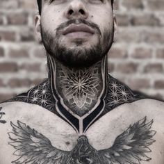 a man with tattoos on his chest is looking at the camera and has an eagle tattoo on his chest