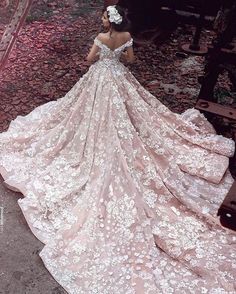 a woman in a wedding dress looking down at the ground