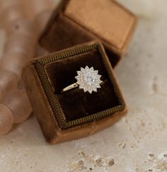 an engagement ring sits in a velvet box