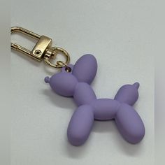 a purple dog keychain is shown on a white surface