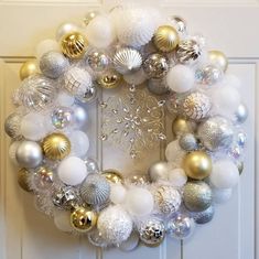 a white wreath with gold and silver ornaments