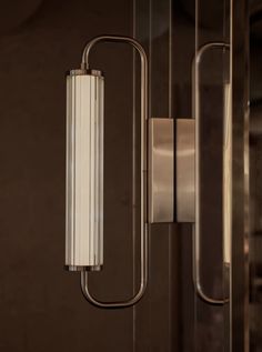 a light that is on the side of a wall next to a glass door and some metal bars