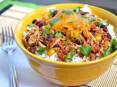 a yellow bowl filled with rice topped with meat and beans, garnished with cilantro