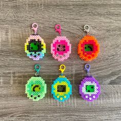 six different colored beaded key chains on a wooden surface