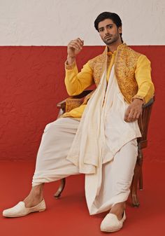 Elevate your style with Yellow Kurta. Crafted from georgette, the kurta features exquisite Resham and sequinned embroidery, a detailed yoke design, and cuffs. Paired with an ivory dhoti and an embroidered dupatta. Perfect for special occasions like Sangeet, Mehendi, Haldi, or as a wedding guest outfit. Composition : Kurta, Dhoti & Dupatta : Viscose Georgette Care: Dry Clean Only and Vacuum Storage This product can be customized for sleeves, length and colour Delivery : 2-4 weeks as the product i Embroidered Slub Silk Sherwani With Traditional Drape, Designer Embroidered Slub Silk Sherwani, Traditional Embroidered Slub Silk Sherwani, Transitional Cotton Silk Sherwani With Cutdana, Bollywood Style Embroidered Slub Silk Sherwani, Traditional Slub Silk Sherwani For Transitional Season, Silk Sherwani With Chikankari Embroidery For Navratri, Bollywood Style Embroidered Cotton Silk Bandhgala, Bollywood Style Designer Cotton Silk Bandhgala