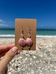 Naturally Pink Seashell Earrings - a unique blend of nature and craftsmanship. Personally found off the beaches of Venice, Florida, these earrings showcase the beauty of naturally pink seashells. Wear a piece of Venice with you wherever you go, and let these Naturally Pink Seashell Earrings become a symbol of coastal charm and effortless beauty. Shell-shaped Jewelry With Matching Earrings For The Beach, Handmade Pink Ocean-inspired Jewelry, Handmade Ocean-inspired Pink Jewelry, Pink Shell Ocean-inspired Jewelry, Beachy Shell Dangle Earrings, Handmade Shell Earrings For Beach Season, Pink Shell-shaped Summer Jewelry, Beach Shell Dangle Earrings, Pink Shell-shaped Jewelry For Summer