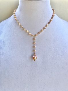 Beautiful and feminine pink hued pearl necklace with gold accents, and a large baroque pearl pendant. Lariat Necklace With Baroque Pearl Chain, Elegant Pink Pearl Drop Necklace, Elegant Pink Pearl Necklace With Pendant, Pink Single Strand Baroque Pearl Jewelry, Long Drop Pearl Necklace With Pearl Pendant, Long Drop Pearl Necklace With Pearl Charm, Pink Single Strand Baroque Pearl Necklace, Pink Baroque Pearl Single Strand Necklace, Pink Baroque Pearl Drop Jewelry