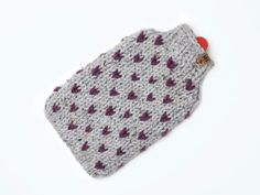 a crocheted bag with hearts on it sitting on a white surface, ready to be used as a knitting project