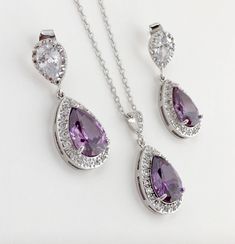 Brilliant & luxurious!! I've created the super sparkly top quality purple amethyst cubic zirconia teardrop bridal set in gold plated brass setting. The includes : #Earrings feature a large teardrop with pear cut purple amethyst cubic zirconia center surrounded by tiny round zirconia crystals. Teardrop dangles from a bright clear cubic zirconia ear stud. Total length of the earrings is 3.5 cms. #Necklace pendant featuring a large teardrop with pear cut purple amethyst cubic zirconia center su Amethyst Wedding, Teardrop Jewelry, Purple Bridesmaids, Bridesmaid Jewelry Sets, Purple Earrings, Purple Crystals, Wedding Jewelry Sets, Bridal Jewelry Sets, Matching Necklaces