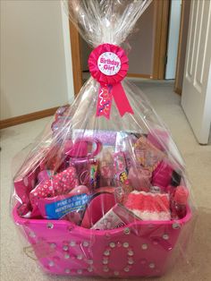 a pink basket filled with lots of toys on top of a carpeted floor next to a door