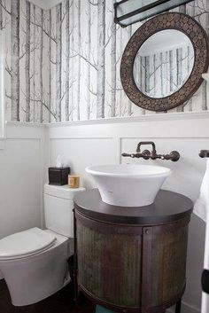 a bathroom with a sink, toilet and mirror on the wall next to each other