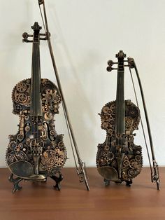 two antique musical instruments sitting on top of a wooden table next to eachother