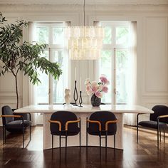 a dining room table with four chairs and a chandelier hanging from the ceiling