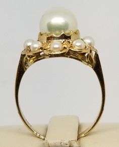 "We do not check prongs for wear or stones for looseness. All items are sold as is-noting that we are a resale shop so everything here had a previous owner! We will include flaws in the description when noted. This is one of the reasons our items are more affordable than new at a jewelry store. Vintage 18K Yellow Gold Pearl Ring, Size 6. Stamped K18 inside band. Main Pearl is 7.2mm others are 2.5mm. Weighs 2.1 dwt. Please stop in often as we will be adding additional vintage fine jewelry beautie Formal 14k Stamped Round Pearl Ring, Domed 14k Stamped Wedding Jewelry, Classic Oval Ring With High Luster, Classic Oval Rings With High Luster, Estate Rings With Prong Setting For Formal Occasions, Estate Style Formal Rings With Prong Setting, Gold Oval Pearl Ring With Prong Setting, Oval Yellow Gold Pearl Ring With High Luster, Oval Pearl Ring In Yellow Gold With High Luster