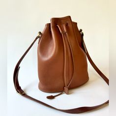 Beautiful Drawstring “Nicolas” Bucket Bag In Hard To Find Color British Tan 10.5” X 12” X 4.5” Drawstring Closure. Main Compartment Has Rear Zip Pocket. Brass Hardware. Strap With 5 Holes For Adjustment, Drop 19”-21” Two Small Spots On Back Of Bag As Shown In Photos. Piping Is In Excellent Condition, Very Clean Interior. Has Original Hangtag. Classic Formal Brown Bucket Bag, Classic Pouch Bag For Errands, Classic Formal Bucket Shaped Shoulder Bag, Classic Formal Shoulder Bag In Bucket Shape, Classic Formal Shoulder Bag With Bucket Shape, Coach Luxury Bucket Bag For Everyday, Classic Leather Bucket Bag, Classic Bucket Shape Shoulder Bag, Classic Shoulder Bag With Bucket Shape