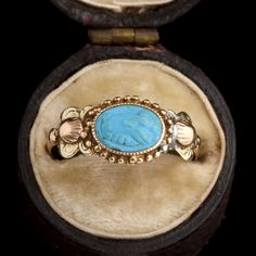 This ring was a commitment jewel. The fede motif (two clasped hands) represents the joining of hands of the couple at a marriage ceremony, a practice that dates back to ancient Rome and was known as 'dextrarum iunctio'. This fede is turquoise-colored glass, pressed in the Georgian era and set into a tricolor gold mounting with shell and flower details at the shoulders. MATERIALS: blue glass, 14k tricolor gold (tests). AGE: c. 1800 SIZE: size 6.5, can be resized; 8.4mm head, 1.3mm shank Antique Cameo Ring, Victorian Oval Intaglio Rings, Antique Cameo Ring In Yellow Gold, Georgian Rings Antique, Luxury Antique Cameo Signet Ring, Clasped Hands, Georgian Era, Marriage Ceremony, Ancient Rome