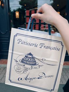 a person is holding a bag that says patisserie frankaise above it