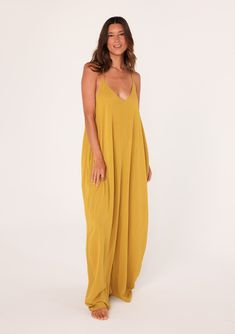 [Color: Mustard] A front facing image of a brunette model wearing a mustard yellow harem maxi dress. This billowy maxi tank top dress features a deep v neckline Chic V-neck Beach Maxi Dress, Flowy V-neck Breezy Maxi Dress, Breezy V-neck Maxi Dress For Brunch, V-neck Maxi Dress For Beach Cover-up In Summer, V-neck Unlined Maxi Dress For Beach, Unlined V-neck Maxi Dress For Beach, Brunch Sundress V-neck Maxi Dress, Solid V-neck Beach Cover-up Dress, Chic Rayon Maxi Dress For Beach Cover-up