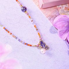 Elevate your ensemble with the ethereal charm of our Dainty Bead Butterfly Pearl Necklace. This exquisite piece features a delicately crafted butterfly pendant, its wings adorned with intricate enamel detailing in deep, regal purple, and highlighted with a cascade of sparkling crystals. A lustrous pearl, symbolizing purity and grace, nestles perfectly against the butterfly, adding a touch of timeless elegance to this enchanting design. The necklace itself is a celebration of color and texture, s Butterfly Pearl Necklace, Bead Butterfly, Nature Details, Astrology Jewelry, Astrology Necklace, Moon And Star Ring, Moon And Star Earrings, Nature Earrings, Jewelry Lockets