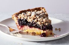 a piece of pie on a white plate with a fork and crumbled topping