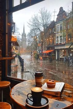 a cup of coffee sitting on top of a table in front of a large window