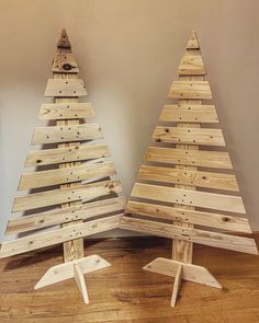 two wooden christmas trees sitting next to each other