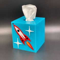 a tissue dispenser with a rocket on it