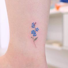 small blue flower tattoo on the ankle