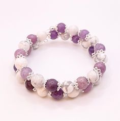 This is a Wire Wrap Beaded Bracelet that adjusts to any size wrist.  Amethyst and White Howlite round beads with Flower silver spacers - Memory Wire Bracelet. This is a Beautiful wrapped Bracelet.  This Bracelet wrap 15 inches in length and is a great piece to add to your jewelry collection. beads are about 8mm. You will receive a nylon gift bag for your gift giving. You will choose gift bag color at checkout. If you have any questions send me a message. Round Spacer Beads Bracelets For Jewelry Making, Spacer Beads Bracelets For Jewelry Making, Silver Adjustable Crystal Bracelet For Meditation, Healing Crystal Bracelet With Spacer Beads, Adjustable Round Spiritual Stretch Bracelet, Adjustable Spiritual Stretch Bracelet, Adjustable Round Crystal Bracelet With Spacer Beads, Adjustable Crystal Bracelet For Jewelry Making, Silver Stretch Bracelet With Natural Stone Round Beads