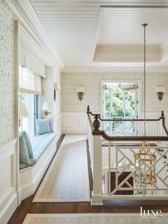 the stairs lead up to the second floor in this white room with floral wallpaper