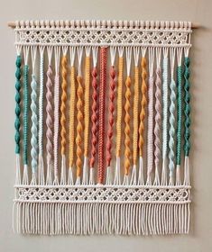 the wall hanging is decorated with multicolored macrame beads