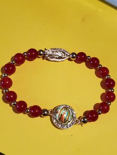 Beautiful Virgen de Guadalupe bracelet color  red. Red Spiritual Crystal Bracelet With Round Beads, Adjustable Red Rosary Bracelet, Red Spiritual Rosary Bracelet, Red Spiritual Charm Bracelet, Spiritual Red Stretch Bracelet Gift, Spiritual Red Stretch Bracelet As Gift, Red Beaded Spiritual Bracelet, Spiritual Red Beaded Bracelet, Spiritual Red Beaded Bracelets