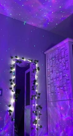 a room with purple lights on the ceiling and a mirror that has vines growing out of it